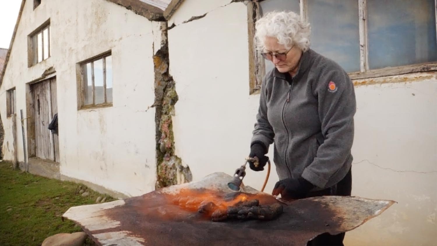 A woman singeing feet of sheep.